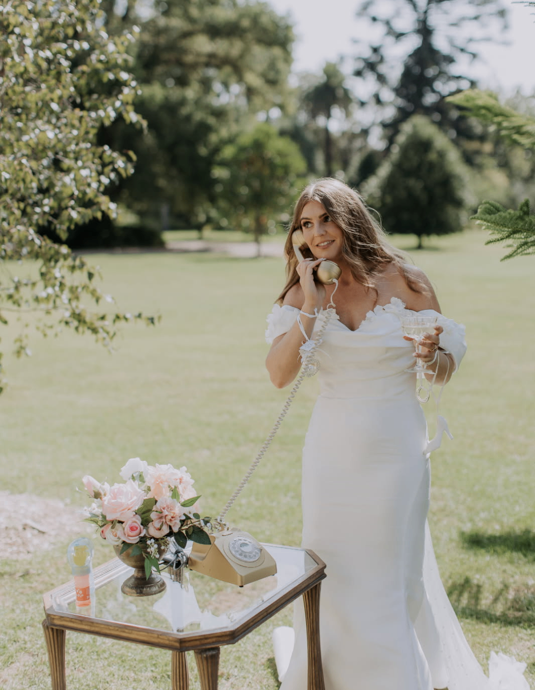 Amber beside a vintage phone display with florals on a glass table