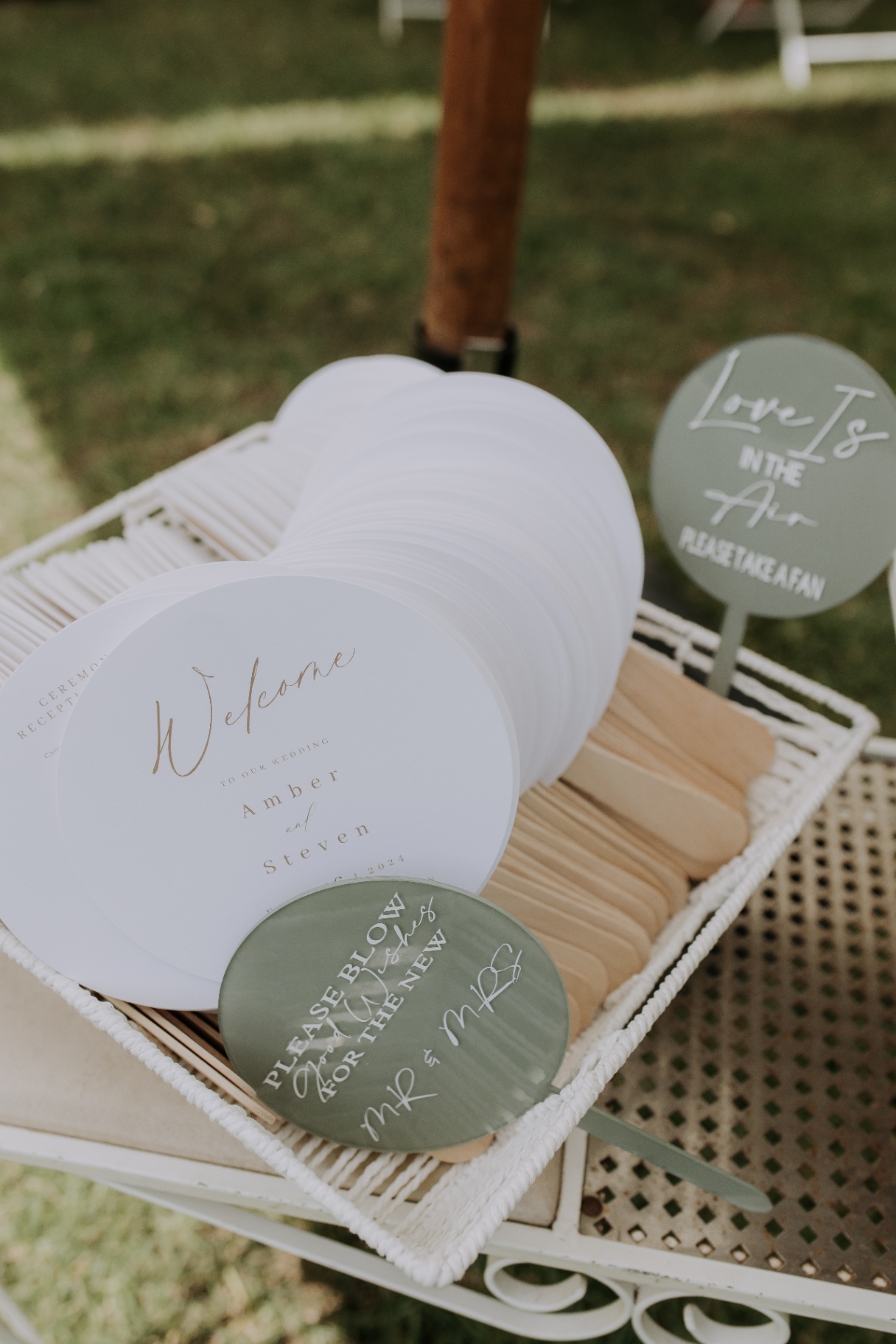 Custom wedding fans displayed in a basket on styled furniture